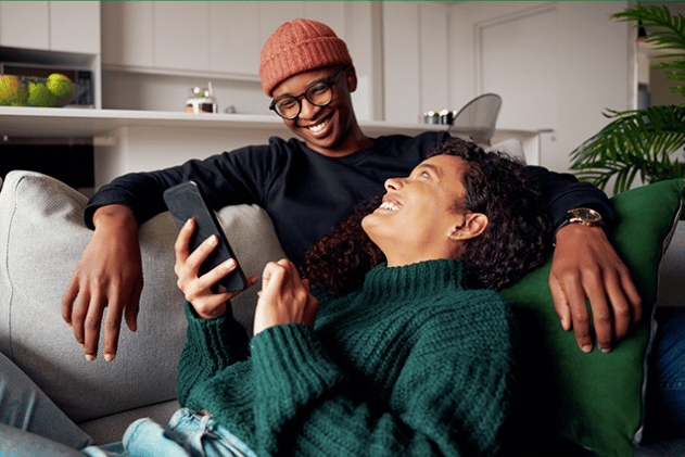 A happy couple using financial wellness apps.